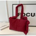 Detail view of burgundy quilted tote bag with soft padded texture and stylish knotted strap - Burgundy