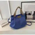 Detail of blue canvas tote bag with brown PU leather trim and adjustable shoulder strap - Blue