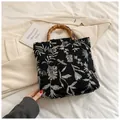 Floral jacquard tote bag with natural bamboo handles and white herbal patterns on black fabric - Black