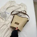 Chic beige straw bucket bag with brown leather trim and adjustable crossbody strap - Khaki