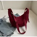 Vue détaillée du sac demi-lune en nylon oxford bordeaux avec bandoulière large et cordes - Rouge