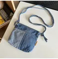Detalle de las costuras de mezclilla bicolor y la etiqueta amarilla en este bolso bandolera - Azul claro