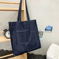 Grande borsa tote in denim blu scuro con cuciture a contrasto e doppie tasche sul supporto - Blu