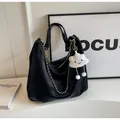 Dettaglio della borsa tote nera con trama litchi, catena argento e ciondolo a nuvola - Con Ciondolo / Nero