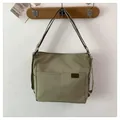 Minimalist light olive green nylon shoulder bag with side D-rings and dual front pockets - Green