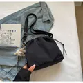 Détail du sac seau noir à cordon avec sangle réglable et breloque en peluche mignonne - Avec Pendentif / Noir