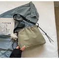 Détail du sac seau vert à cordon avec étiquette KOKO et bandoulière noire réglable - Avec Pendentif / Vert