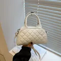 White quilted Boston bag with dual handles and long shoulder strap in minimalist style - White