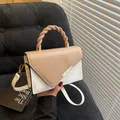 Minimalistische beige-weiße Handtasche mit geflochtenem Griff und goldenem Metallverschluss - Khaki