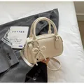 Mini bolso Boston crema con colgante de lazo de perlas y correa de hombro ajustable - Blanco Roto