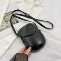 Minimalist black PU leather saddle bag with adjustable strap and embossed fashion text - Black