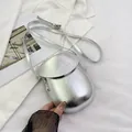 Minimalist silver saddle-shaped crossbody phone bag with sleek metallic finish and thin strap - Silver