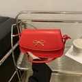 Borsa sottobraccio in pelle rossa opaca con fibbia a fiocco dorato e tracolla sottile - Rosso