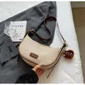 Borsa a mezzaluna intrecciata beige con finiture in pelle marrone e ciondolo mascotte - Bianco Crema con Pendente