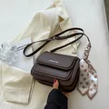 Detailed view of hand-held dark brown crossbody bag with polka dot scarf and golden logo - No Pendant / Coffee