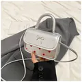 Silver metallic mini crossbody bag with red polka dots and a decorative metal bow - Silver
