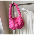 Gros plan du sac matelassé rose vif montrant la texture plissée et le nylon gonflant - Rose rouge