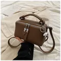 Brown textured Boston bag featuring silver ball charm and adjustable shoulder strap - Coffee