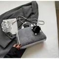 Detalle de bolso bandolera de mezclilla gris con ribete plateado y colgante peluche - Plateado & Negro Grande