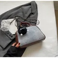 Detalle de bolso bandolera de mezclilla y cuero marrón con tachuelas sobre chaqueta gris - Marrón & Azul Claro Grande