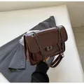 Sac bandoulière en cuir verni marron foncé avec surpiqûres en V et fermoir argenté - Café