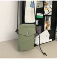 Dettaglio della mini borsa a tracolla in nylon con bottone a pressione in metallo e zip - Verde
