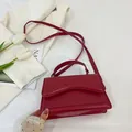Dunkelrote minimalistische Umhängetasche in Quadratform mit Wellensteppung - Rot