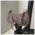 Chic leopard print baguette bag featuring a half-moon shape and golden hardware - Khaki