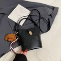 Minimalist black bucket bag with a cute brown dog charm and golden metal buckle details - With Pendant / Black