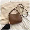 Détail de la texture tressée marron et de la bandoulière réglable du sac chic - Café