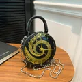 Sac bandoulière rond avec motif horloge et notes de musique dorées sur texture noire - Noir