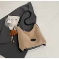 Detalle del bolso de ante caqui con base de cuero negro y colgante de peluche marrón - Con Colgante / Caqui