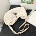 Minimalist beige pleated crossbody bag with drawstring closure and wide adjustable strap - White