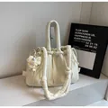 Detail of beige quilted drawstring shoulder bag with plush pendant on marble surface - Cream White with Pendant
