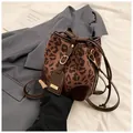 Vue détaillée du sac seau léopard avec cordon en cuir et finitions métalliques dorées - Léopard Café