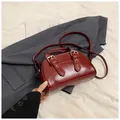 Detail view of burgundy oil-wax leather handbag with adjustable buckles and silver hardware - Red (No Pendant)