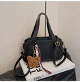 Black litchi grain leather tote bag with a plush bear charm and detachable shoulder strap - Black