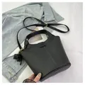 Elegant black lychee leather bucket bag with top handles and adjustable strap - Black