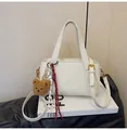 Creamy white lychee texture handbag with teddy bear charm and adjustable shoulder strap - Off White