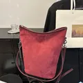 Sac seau chic en daim rouge foncé avec bandoulière réglable et détails argentés - Bordeaux