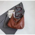 Detail of a brown leather shoulder bag with white contrast stitching and silver chain - Brown