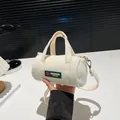 Beige corduroy cylinder handbag with green heart patch and adjustable crossbody strap - White