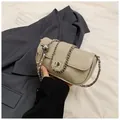 Close-up of beige oil-wax leather texture with silver metal chain and rotary lock - Trench Gray