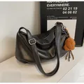 Detail of black pleated shoulder bag featuring fashion leather label and brown teddy charm - Black