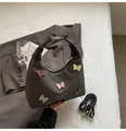 Dark grey canvas handbag featuring colorful butterfly appliqués and a black leather handle - Dark Gray