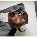 Vintage brown leather underarm bag with decorative rivets and soft pleats - Brown
