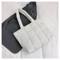 Quilted white puffer tote bag with large square stitching on a grey blazer backdrop - White