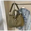 Olive green quilted nylon tote bag with wave stitching and white toggle accents - Green