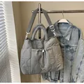 Chic grey quilted nylon tote bag with wavy stitching and adjustable wide strap - Gray