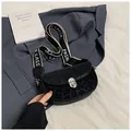 Detail of crossbody saddle bag featuring leopard print panel and classic fashion strap - Black
